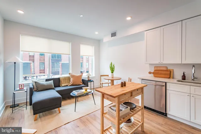 a living room with furniture and a kitchen area