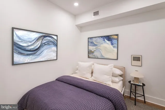 a bedroom with a bed and a painting on the wall