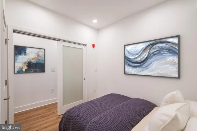a bedroom with a bed and a painting on the wall