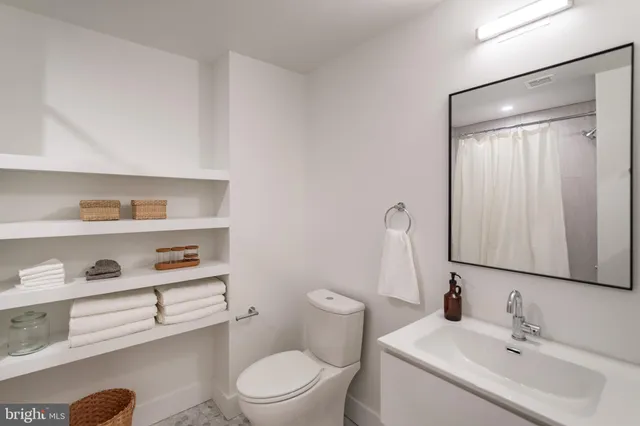 a bathroom with a sink a toilet and a mirror