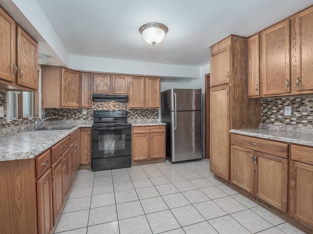 125 Columbia Road Lowell, MA 01854 - Photo 8 of 32 a kitchen with stainless steel appliances granite countertop a refrigerator sink and cabinets
