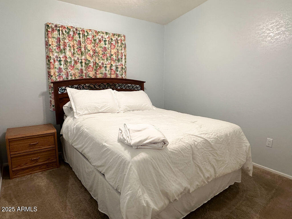 2054 North Thornton Road, Unit 140 Casa Grande, AZ 85122 - Photo 14 of 16 a large bed sitting in a bedroom next to a window