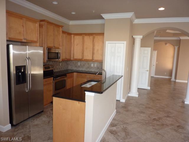 3550 Lansing Loop, Unit 201 Estero, FL 33928 - Photo 4 of 8 a kitchen with stainless steel appliances granite countertop a refrigerator and a sink
