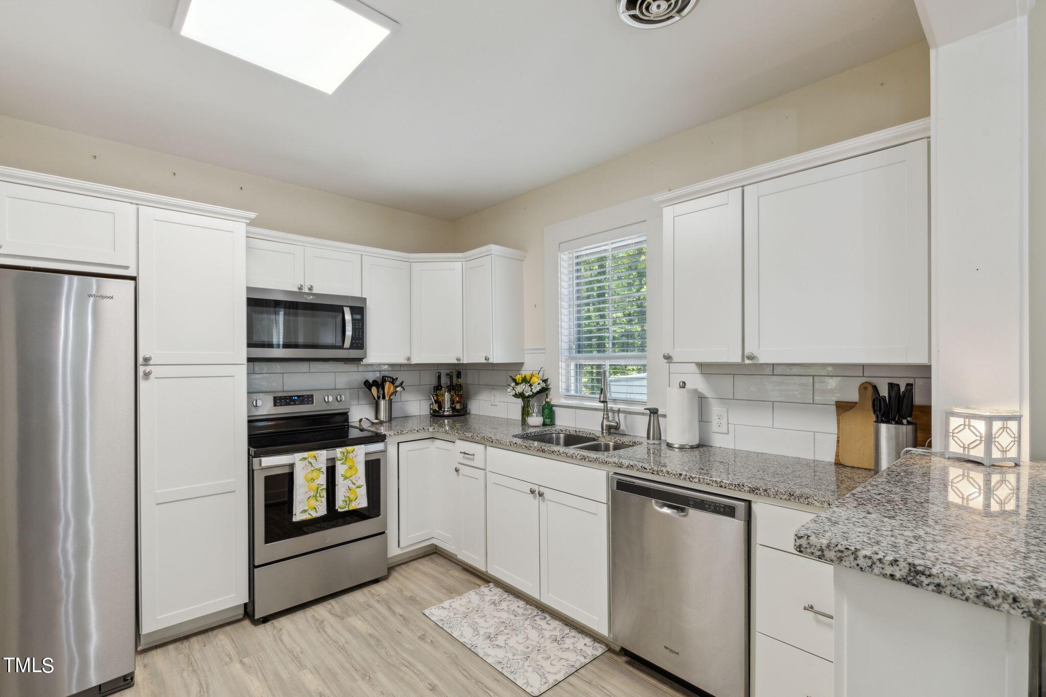 6321 Johnson Pond Road Fuquay-Varina, NC 27526 - Photo 43 of 50 a kitchen with stainless steel appliances granite countertop a sink stove and refrigerator