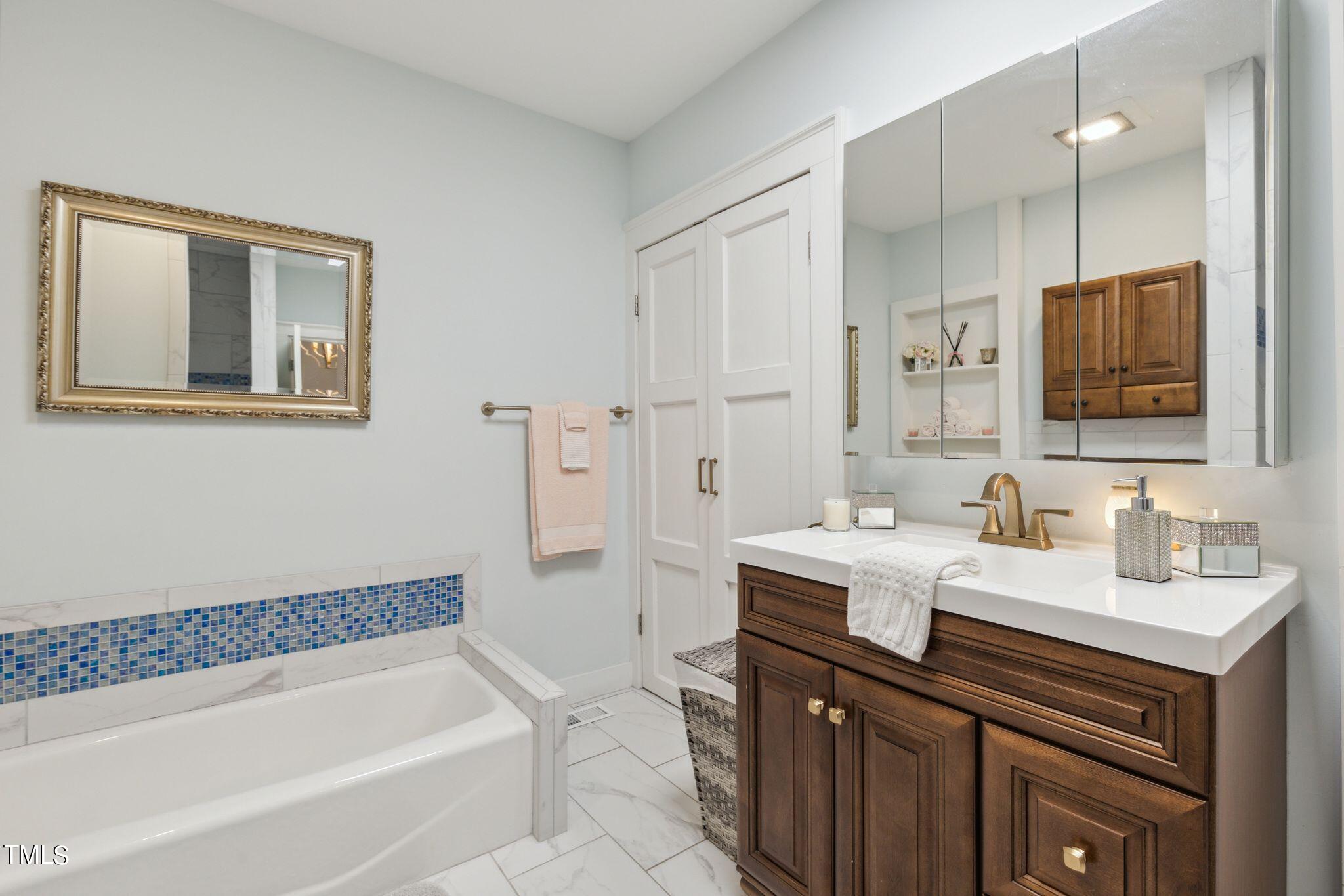 6321 Johnson Pond Road Fuquay-Varina, NC 27526 - Photo 46 of 50 a bathroom with a tub sink and mirror