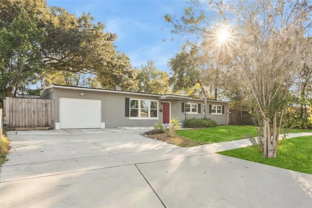 a view of a yard in front of a house with large trees