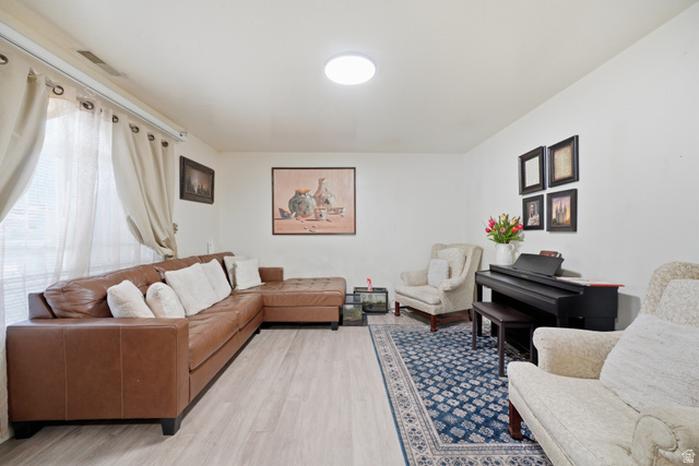 203 North Geneva Road, Unit 10 Provo, UT 84601 - Photo 2 of 30 Spacious living area featuring light wood-finish flooring, a contemporary ceiling light fixture, and large window with blinds