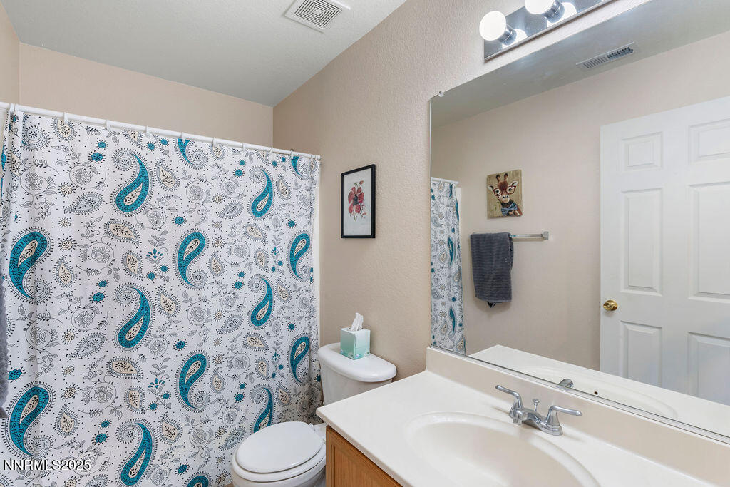 7685 Bichon Street Reno, NV 89506 - Photo 15 of 29 a bathroom with a sink and mirror with toilet