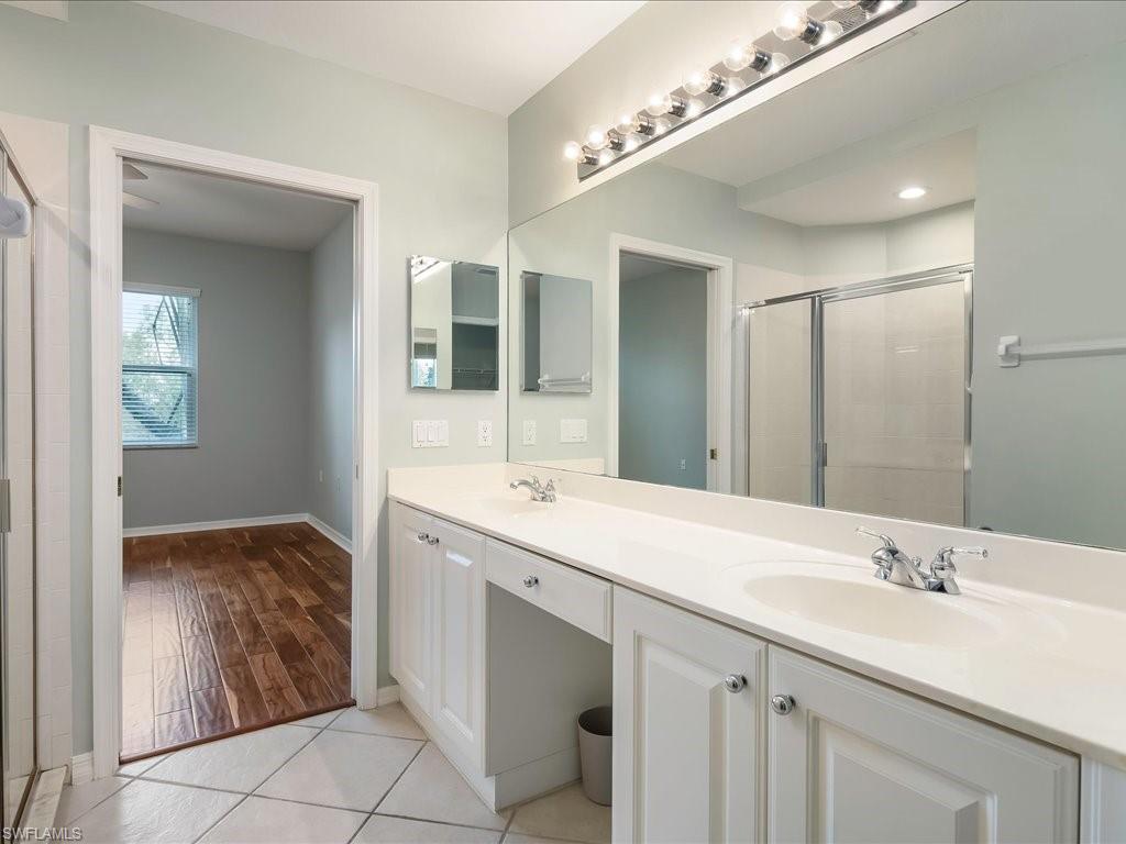 4655 Hawks Nest Way, Unit 103 Naples, FL 34114 - Photo 19 of 33 a bathroom with a sink double vanity and a mirror