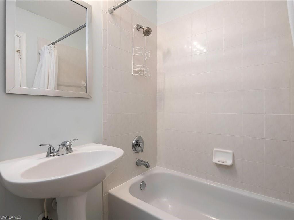 4655 Hawks Nest Way, Unit 103 Naples, FL 34114 - Photo 21 of 33 a bathroom with a sink a toilet and mirror