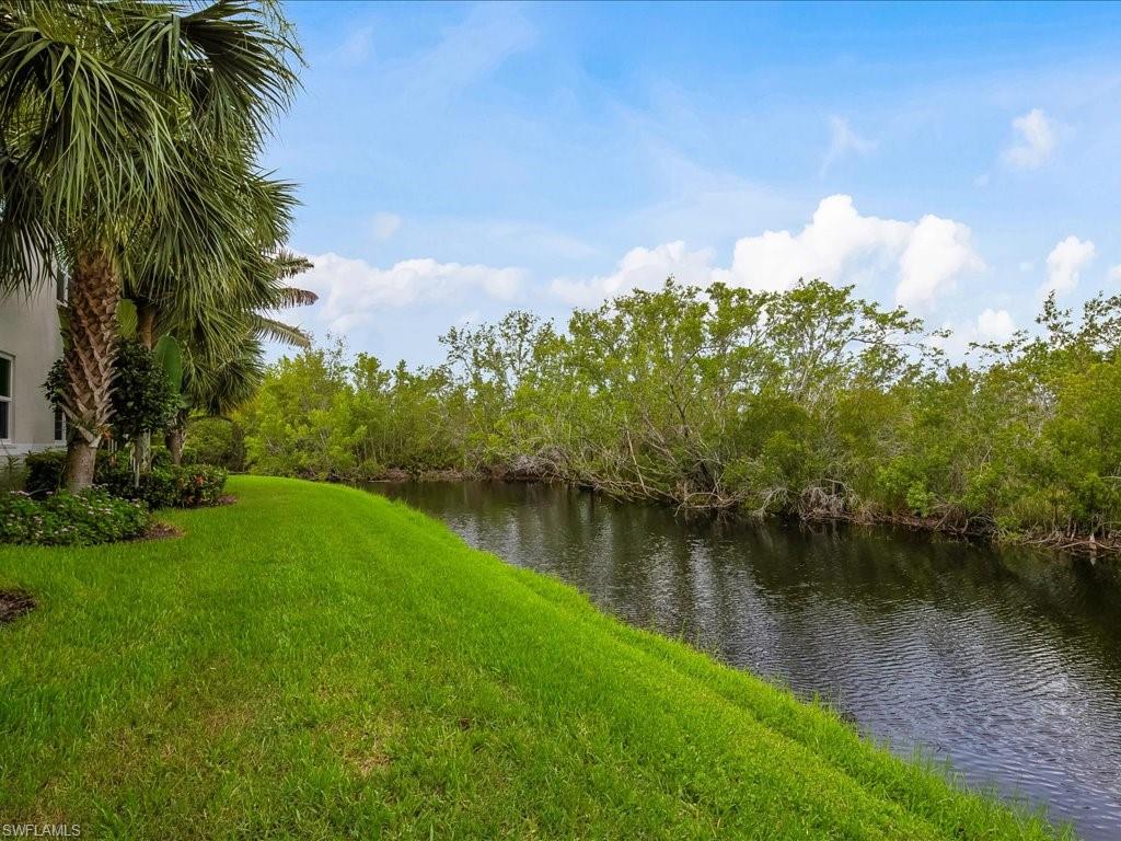 4655 Hawks Nest Way, Unit 103 Naples, FL 34114 - Photo 24 of 33 a view of a lake with a yard