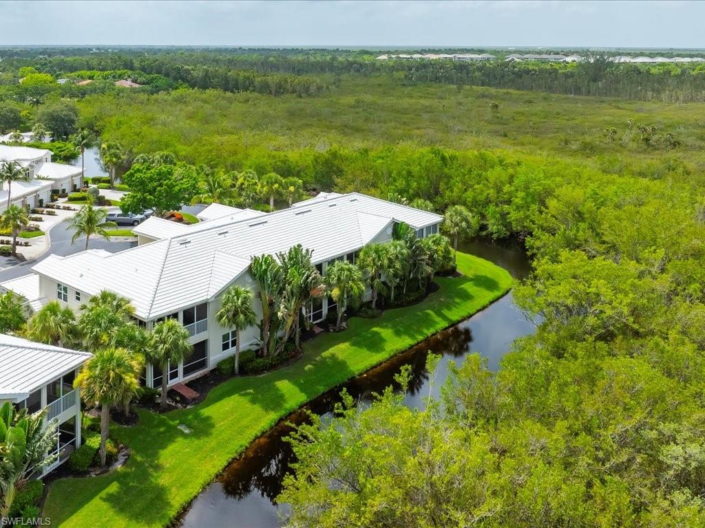 4655 Hawks Nest Way, Unit 103 Naples, FL 34114 - Photo 25 of 33 a view of a lake with a yard