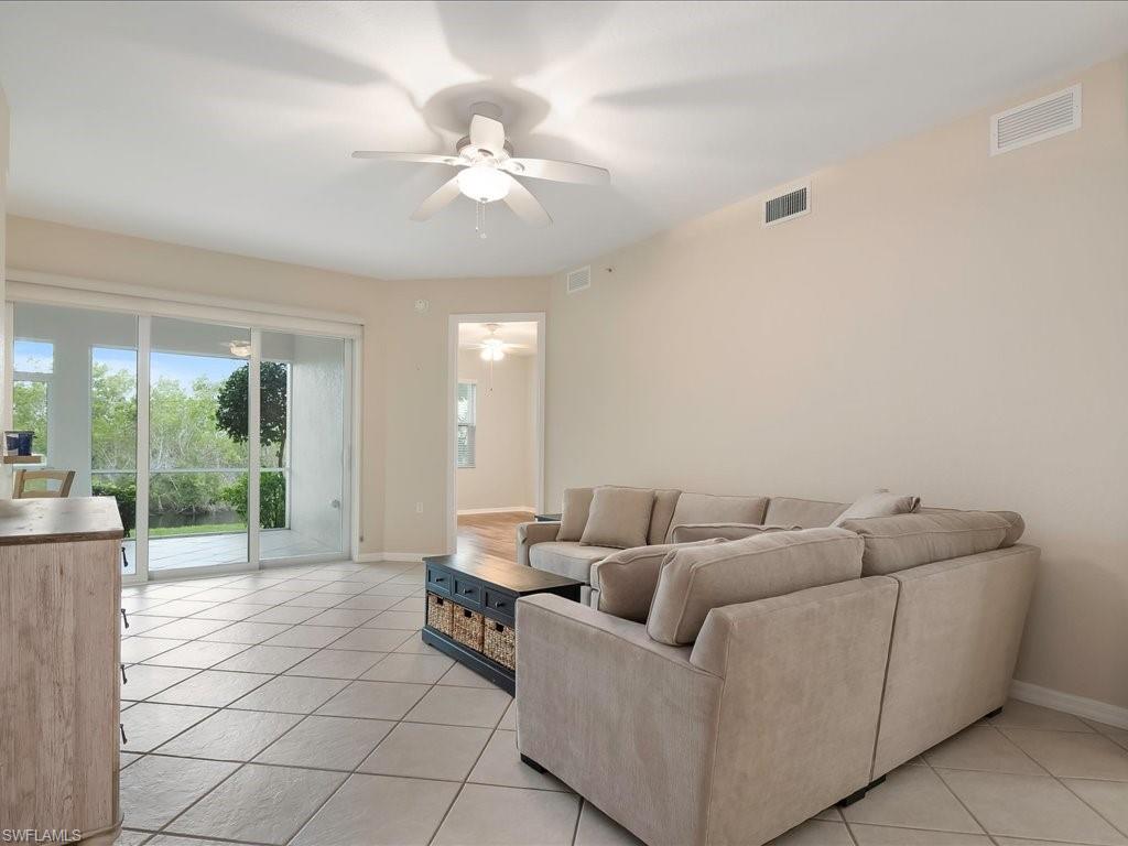 4655 Hawks Nest Way, Unit 103 Naples, FL 34114 - Photo 5 of 33 a living room with furniture and a large window