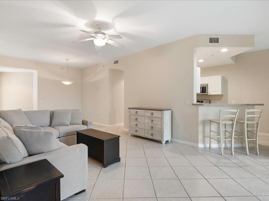 4655 Hawks Nest Way, Unit 103 Naples, FL 34114 - Photo 7 of 33 a living room with furniture and a chandelier