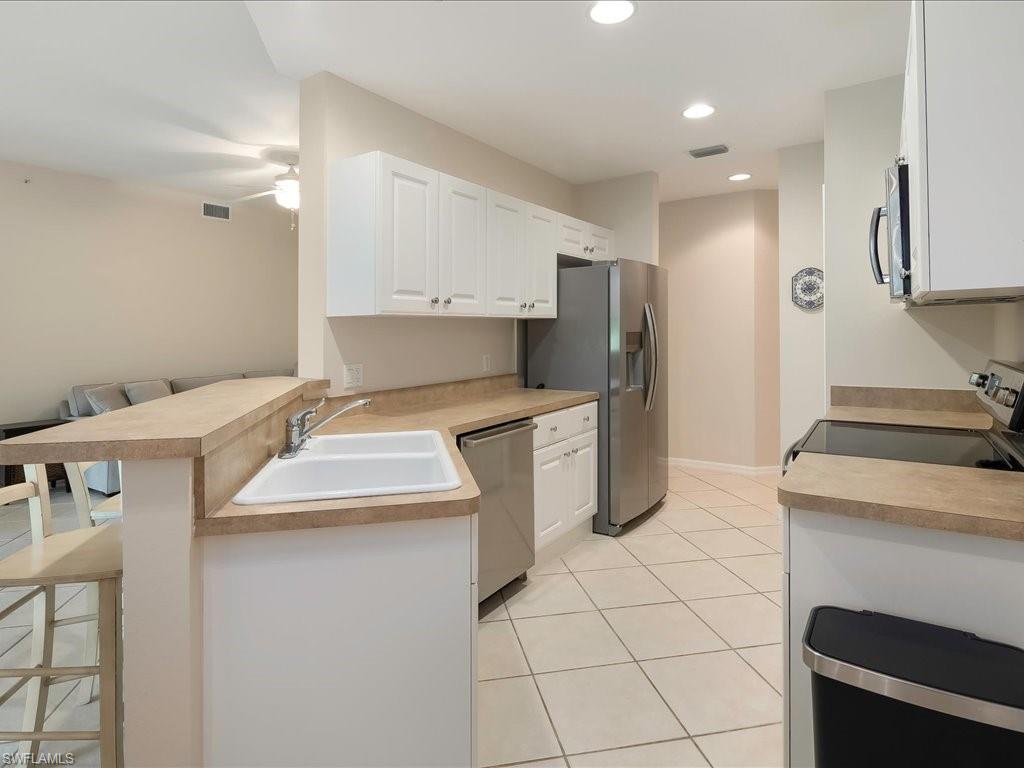 4655 Hawks Nest Way, Unit 103 Naples, FL 34114 - Photo 8 of 33 a kitchen that has a sink cabinets and stainless steel appliances