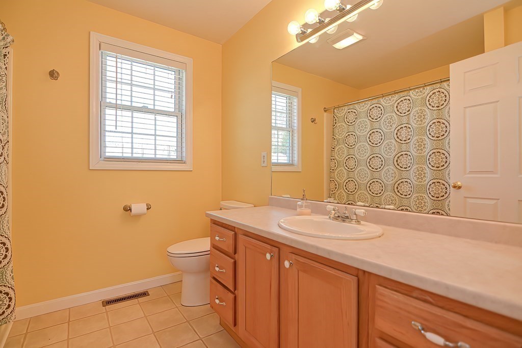 47 Hidden Road Dracut, MA 01826 - Photo 19 of 28 a bathroom with a sink a toilet and a mirror