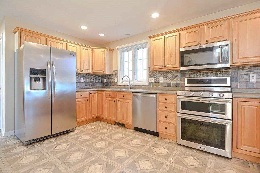 47 Hidden Road Dracut, MA 01826 - Photo 3 of 28 a kitchen with granite countertop stainless steel appliances a stove sink and microwave
