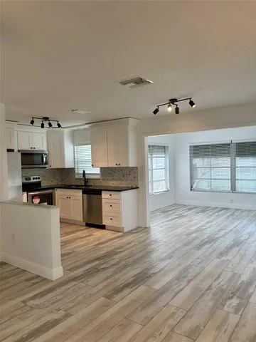 a kitchen with granite countertop a stove top oven and cabinets