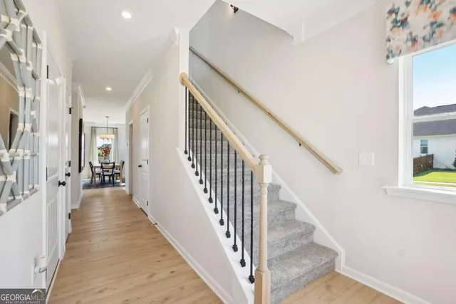 a view of a hallway with wooden floor and staircase