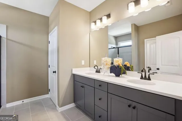 a bathroom with a double vanity sink mirror and next to a window