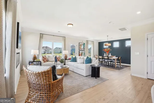 a living room with furniture and a dining table with garden view