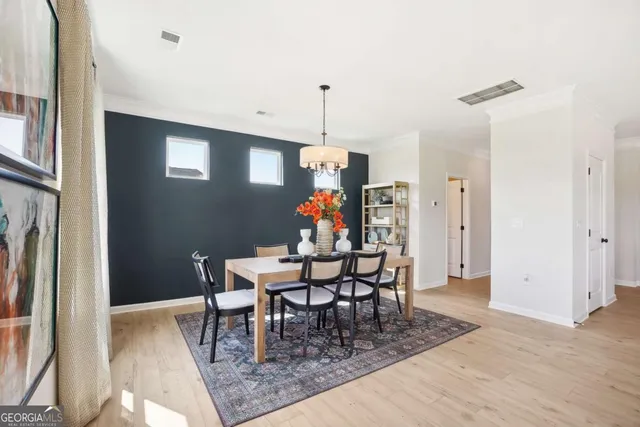 a dining room with furniture wooden floor a rug and a chandelier