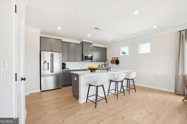 a kitchen with stainless steel appliances a refrigerator and a stove top oven