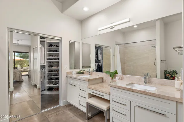 a bathroom with a double vanity sink a toilet and shower