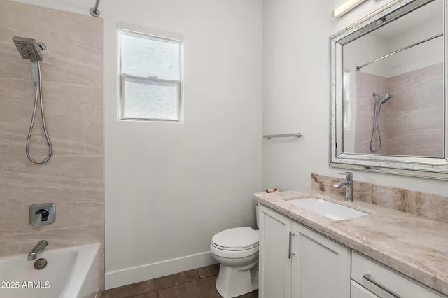 a bathroom with a granite countertop sink a toilet and shower