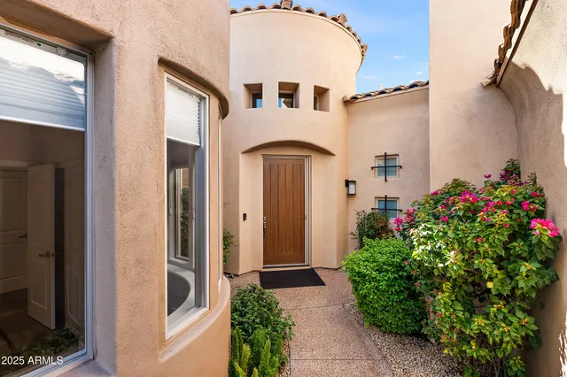 a front view of a house with plants