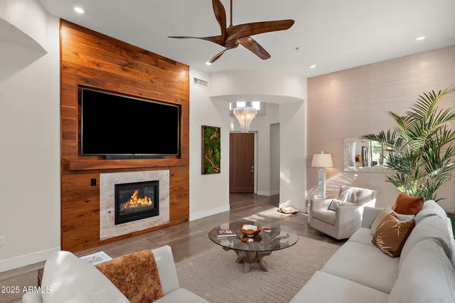 a living room with furniture a flat screen tv and a fireplace