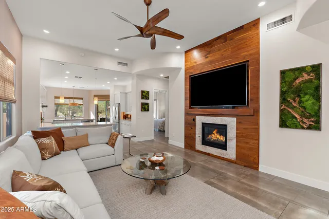 a living room with furniture a flat screen tv and a fireplace