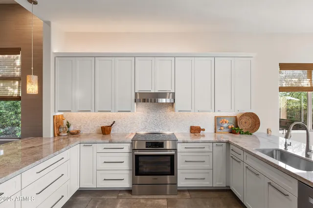 a kitchen with white cabinets and appliances
