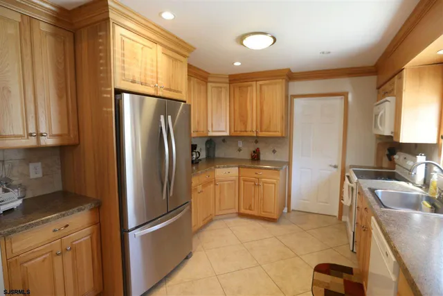 a kitchen with a refrigerator sink and cabinets