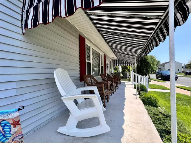 a view of a patio with table and chairs potted plants with wooden floor and fence
