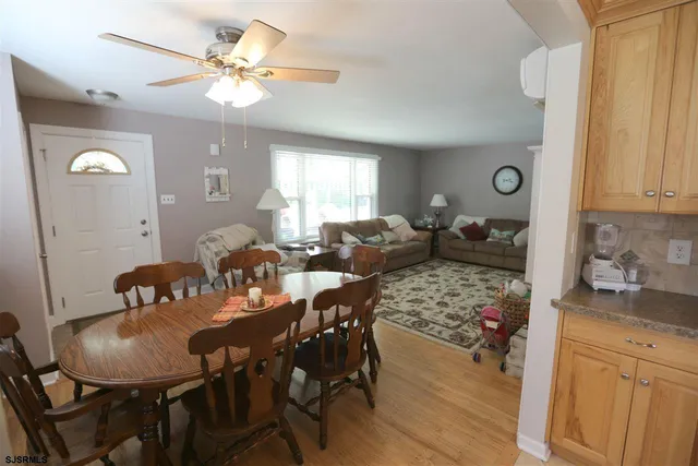 a view of a a dining room with furniture window and wooden floor