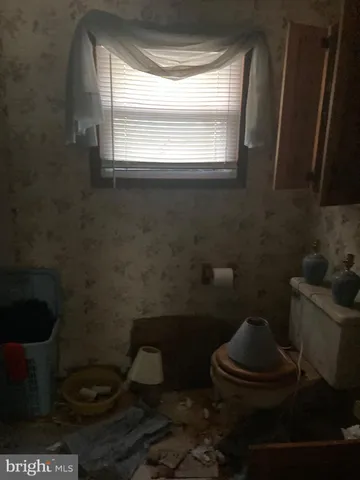 a bathroom with a toilet and a window