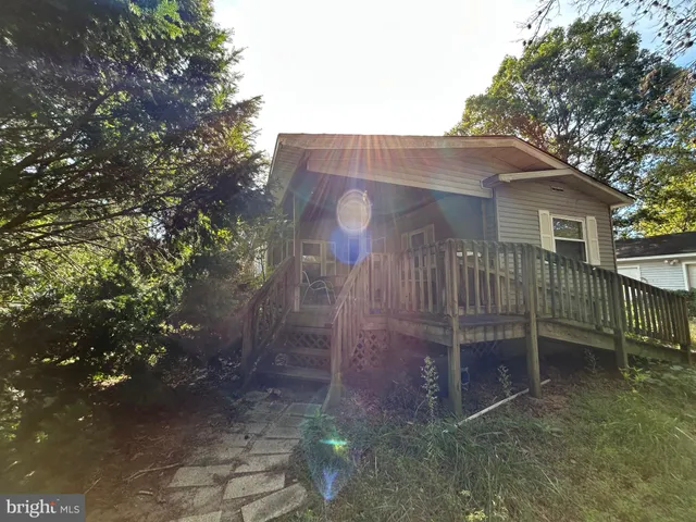 a view of a small house with a yard and large tree