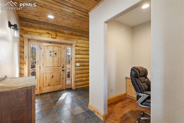 111 Blue Spruce Road Divide, CO 80814 - Photo 9 of 46 Foyer featuring wooden ceiling, recessed lighting, log walls, and stone tile flooring
