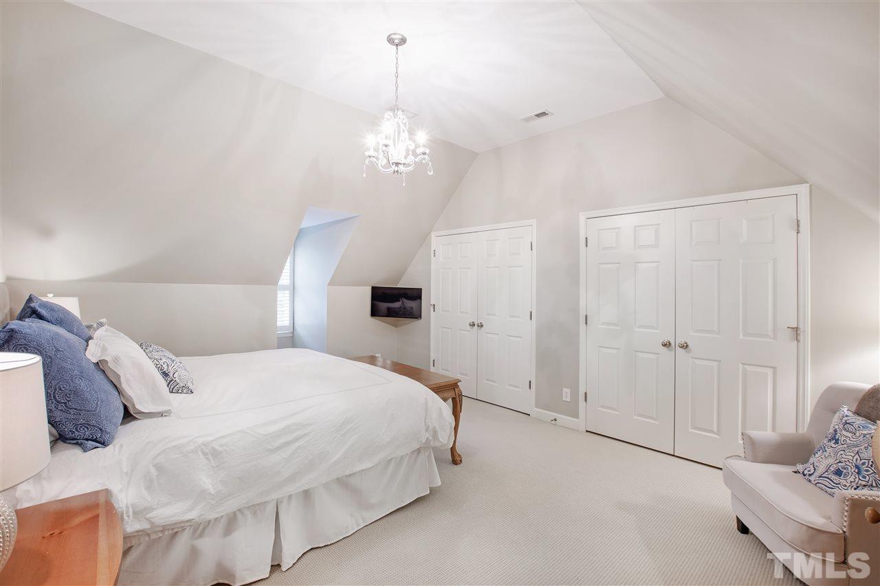 2324 Oxford Road Raleigh, NC 27608 - Photo 28 of 30 a spacious bedroom with a bed and a chandelier