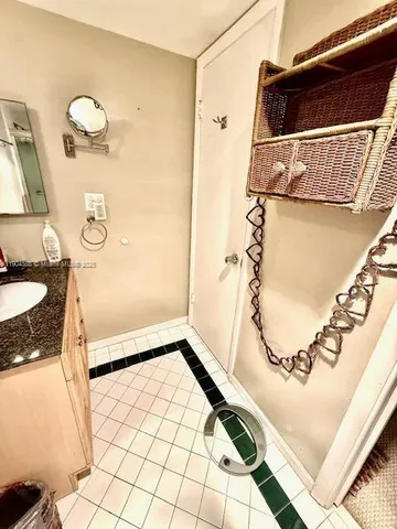 a bathroom with a granite countertop sink a mirror and shower