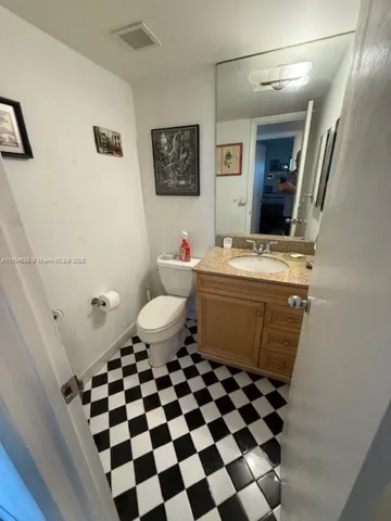 a bathroom with a black and white checkered floor