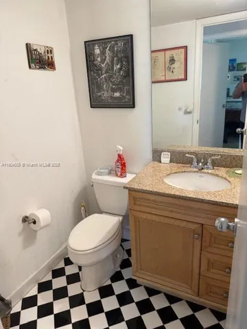 a bathroom with a sink a toilet a mirror and shower curtain