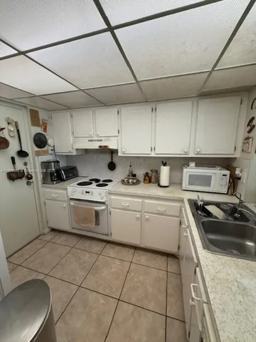 a kitchen with cabinets appliances a sink and a counter top