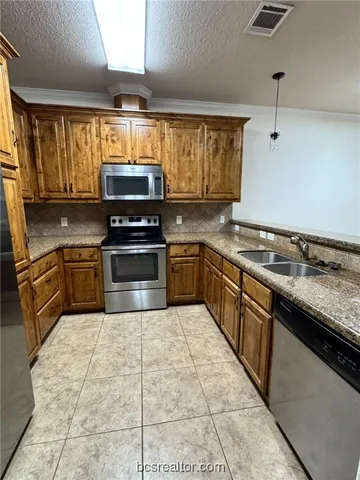 a kitchen with stainless steel appliances granite countertop a stove sink and cabinets