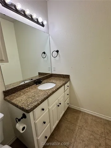 a bathroom with a granite countertop sink a mirror and shower