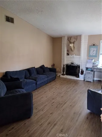 a view of a livingroom with wooden floor and furniture