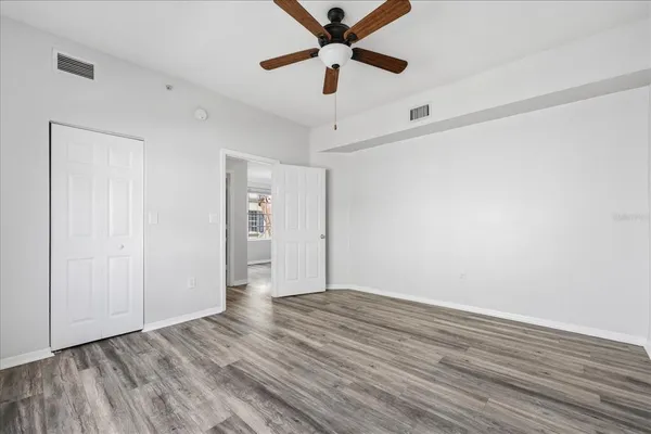 a view of an empty room with window and a ceiling fan