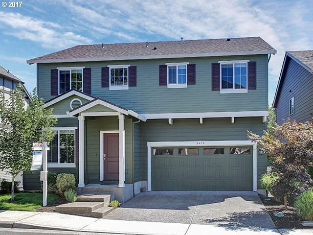 a front view of a house with a yard and garage