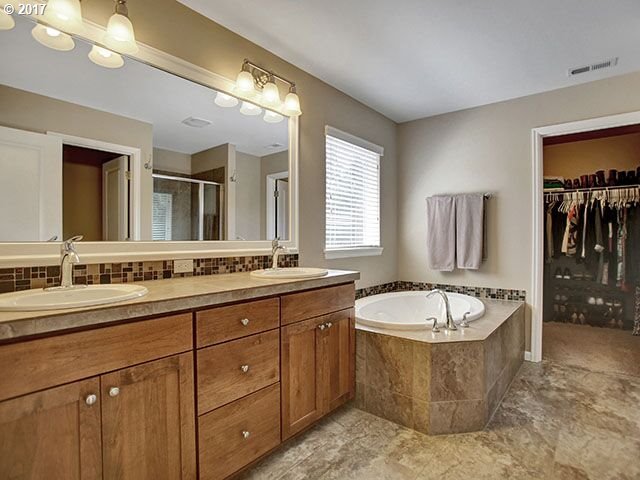 9478 Northwest Ember Lane Portland, OR 97229 - Photo 11 of 23 a bathroom with a tub sink and mirror